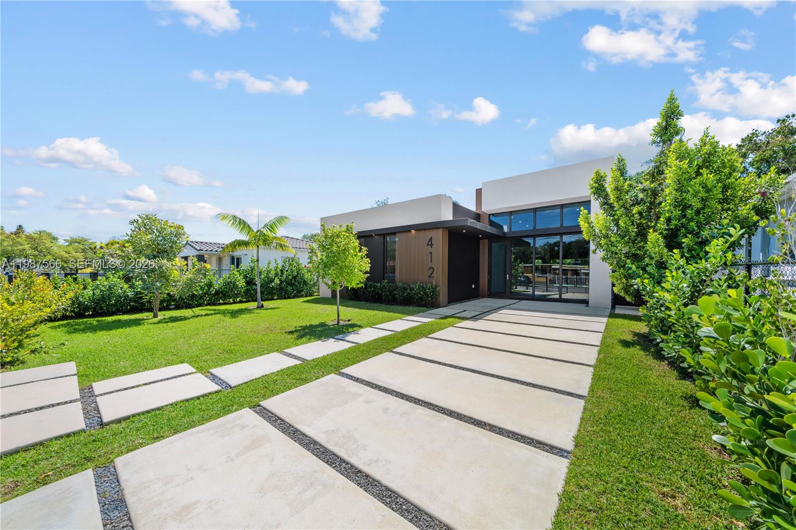 A modern single-story house with a concrete paver driveway and a landscaped front lawn — 412 NW 47th St, Miami FL 33127, MIAMI, FL