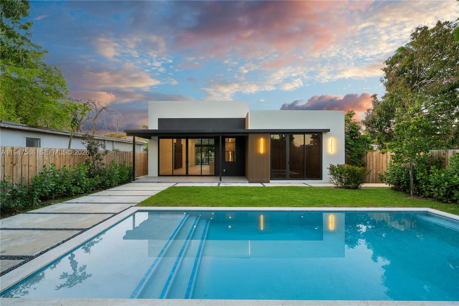 A modern house with a flat roof and large glass doors overlooks a swimming pool — 412 NW 47th St, Miami FL 33127, MIAMI, FL
