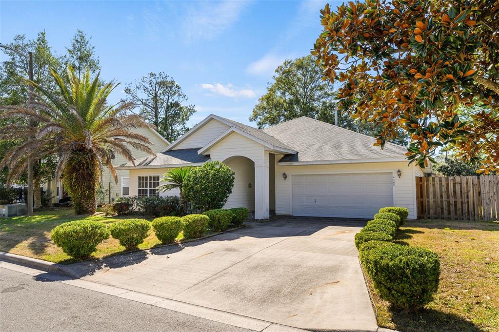 A single-story house with a beige exterior, a two-car garage, and a concrete driveway — 4360 NW 36TH TERRACE, GAINESVILLE, FL