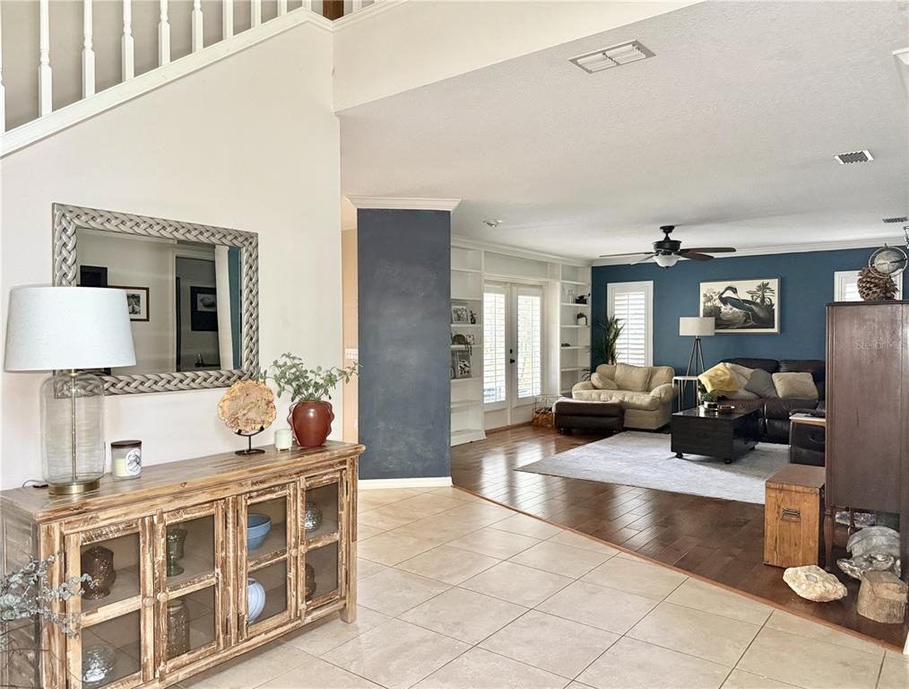 A foyer with a wooden cabinet leads into a living room with blue accent walls — 9306 ALANBROOKE ST, TEMPLE TERRACE, FL