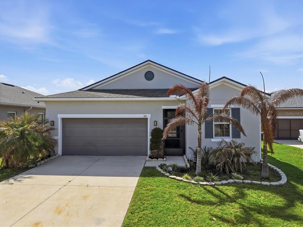 A single-story house with a gray exterior, a two-car garage, and two palm trees — 120 SUMMERSHORE DRIVE, AUBURNDALE, FL