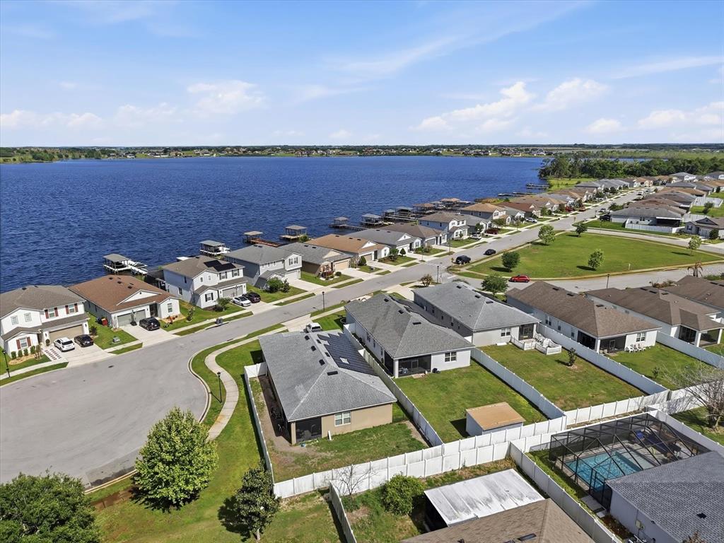 An aerial view shows suburban houses along a lake with private docks and fenced yards — 120 SUMMERSHORE DRIVE, AUBURNDALE, FL