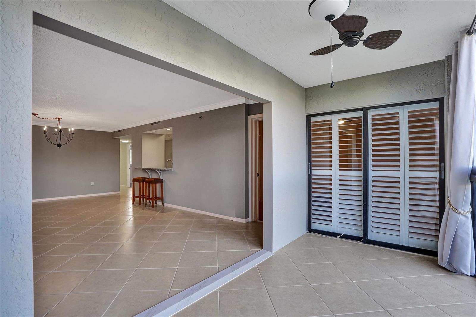 A sunroom with tile flooring and a ceiling fan opens into a living area — 2334 S Cypress Bend Drive # 304, Pompano Beach FL 33069, POMPANO BEACH, FL