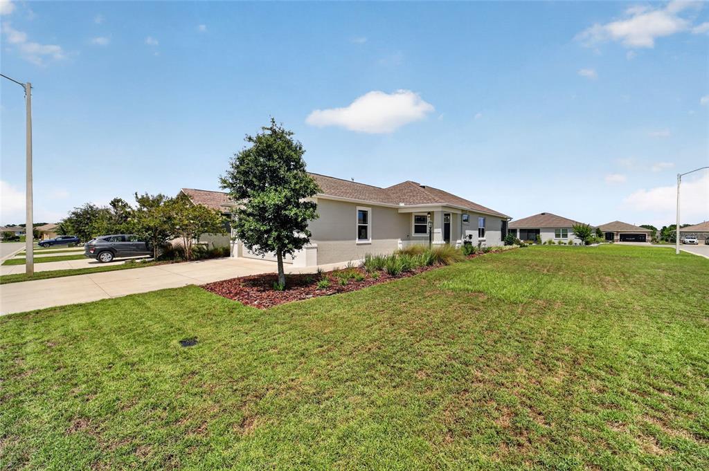 A single-story house with a gray stucco exterior, a two-car garage, and a landscaped yard — 7935 SW 89TH TERRACE, OCALA, FL