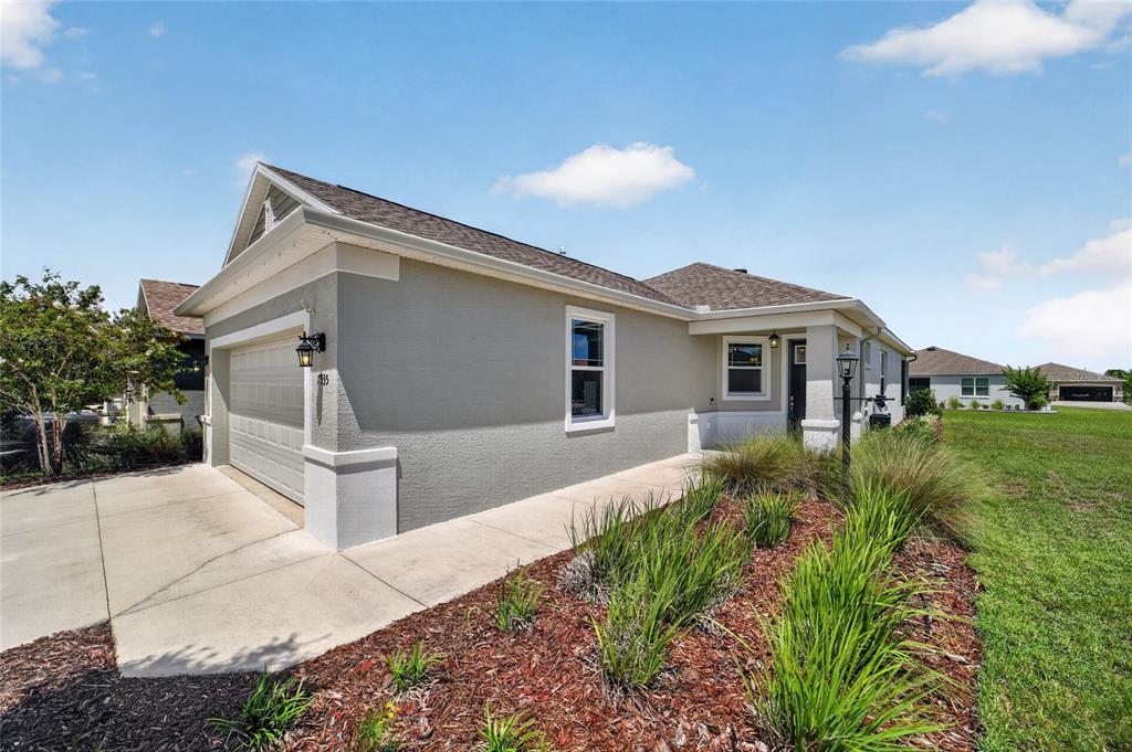 A covered concrete front porch features a dark door and a single light fixture — 7935 SW 89TH TERRACE, OCALA, FL