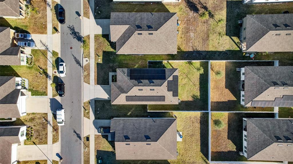 An aerial view shows several suburban houses with dark roofs and driveways along a street — 5860 BOVINE DRIVE, ST CLOUD, FL