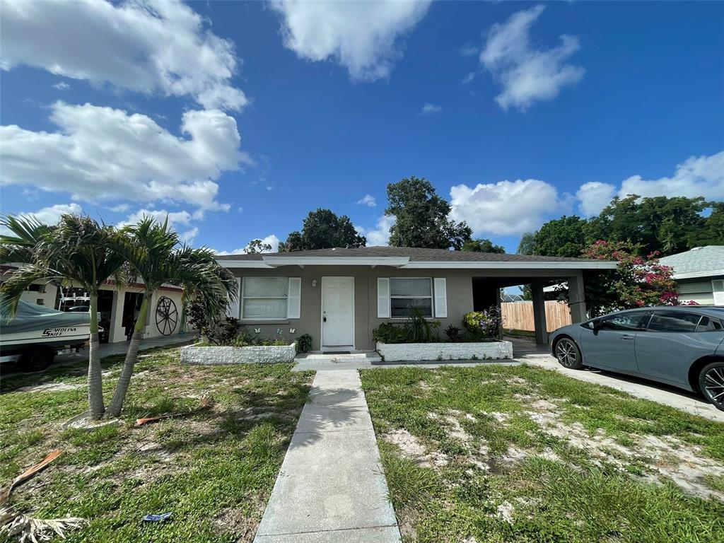 A single-story house with a white front door, two windows, and a carport — 3305 13TH AVENUE W, BRADENTON, FL