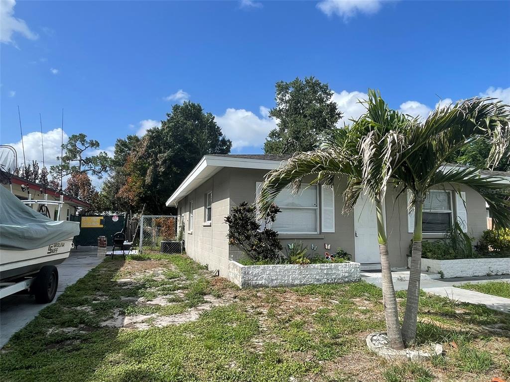 A single-story gray concrete block house features a palm tree in the front yard — 3305 13TH AVENUE W, BRADENTON, FL