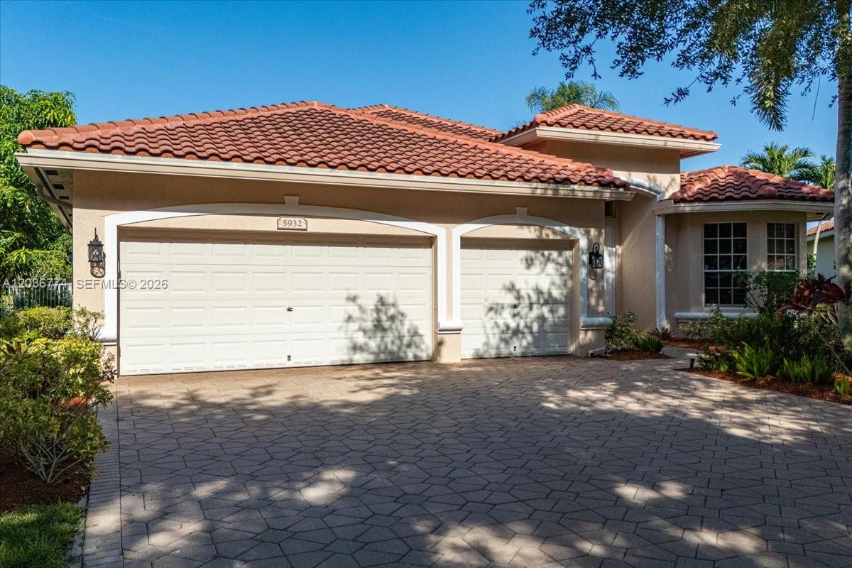 A single-story house with a tiled roof, two-car garage, and a paved driveway — CORAL SPRINGS, FL