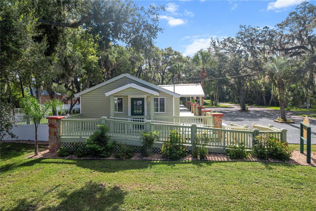 A light green house with a wooden ramp and deck sits on a grassy lot — 107 NE 4TH STREET, CRYSTAL RIVER, FL