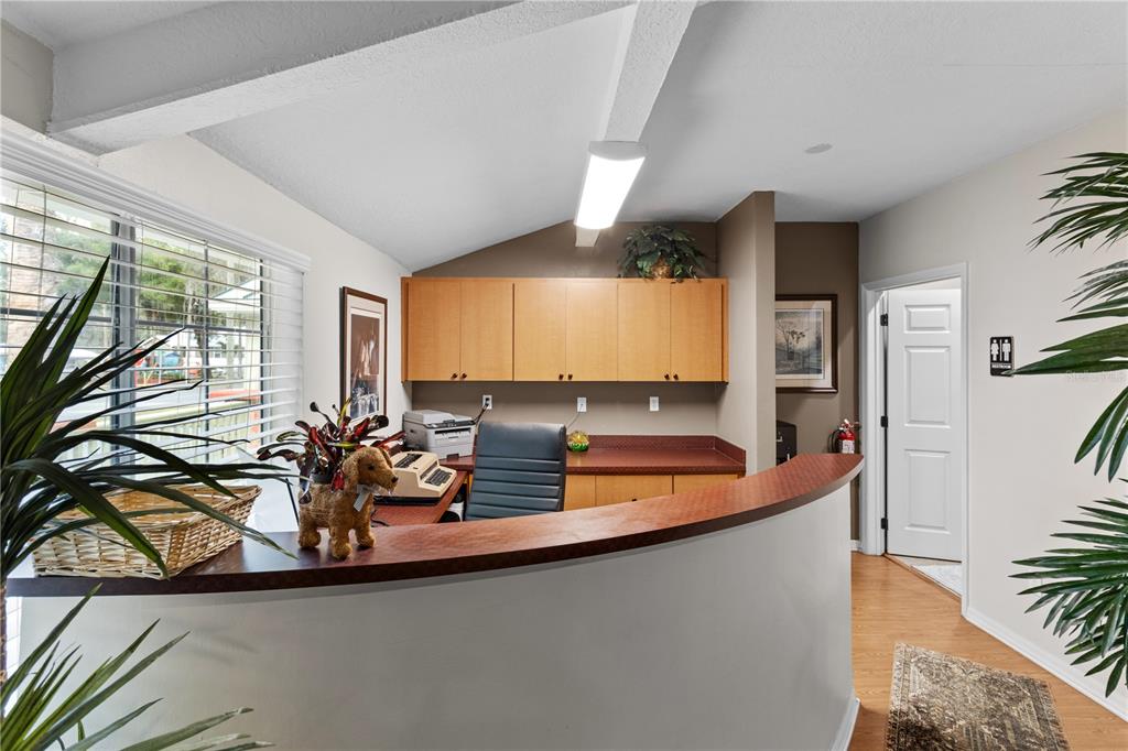A reception area features a curved wooden desk, light wood cabinets, and a white door — 107 NE 4TH STREET, CRYSTAL RIVER, FL