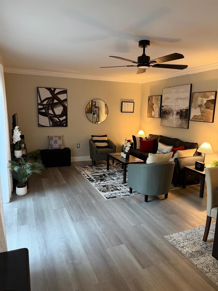 A living room features gray wood-look flooring, a ceiling fan, and a neutral color palette — 2949 SW 22nd Circle # 27a, Delray Beach FL 33445, DELRAY BEACH, FL