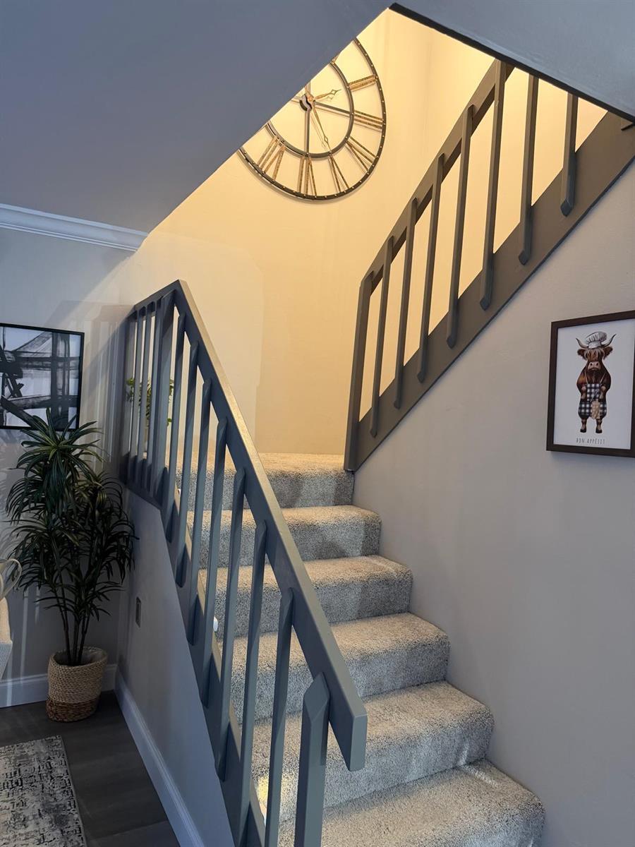 A carpeted staircase features dark gray railings and a large wall clock above the landing — 2949 SW 22nd Circle # 27a, Delray Beach FL 33445, DELRAY BEACH, FL
