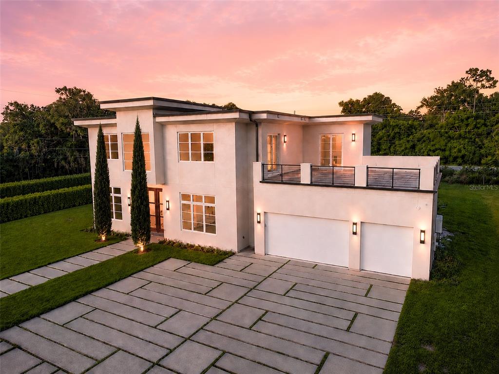 A modern two-story house with a concrete driveway, a flat roof, and a second-floor terrace — 1351 VIA MARKHAM COURT, LAKE MARY, FL