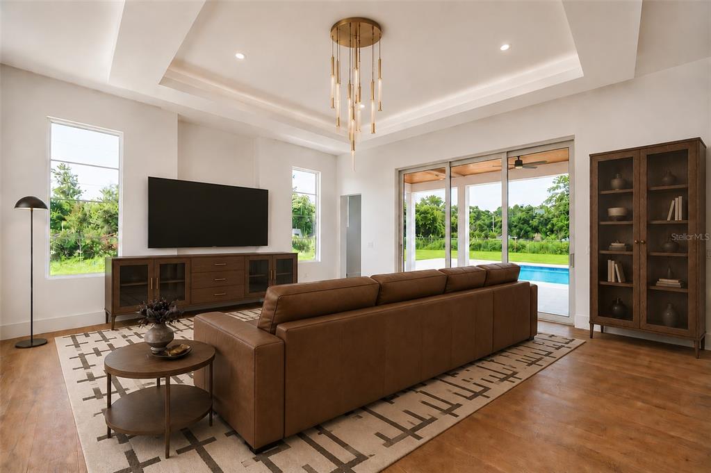 A living room features a brown leather sofa, a television, and a modern chandelier — 1351 VIA MARKHAM COURT, LAKE MARY, FL