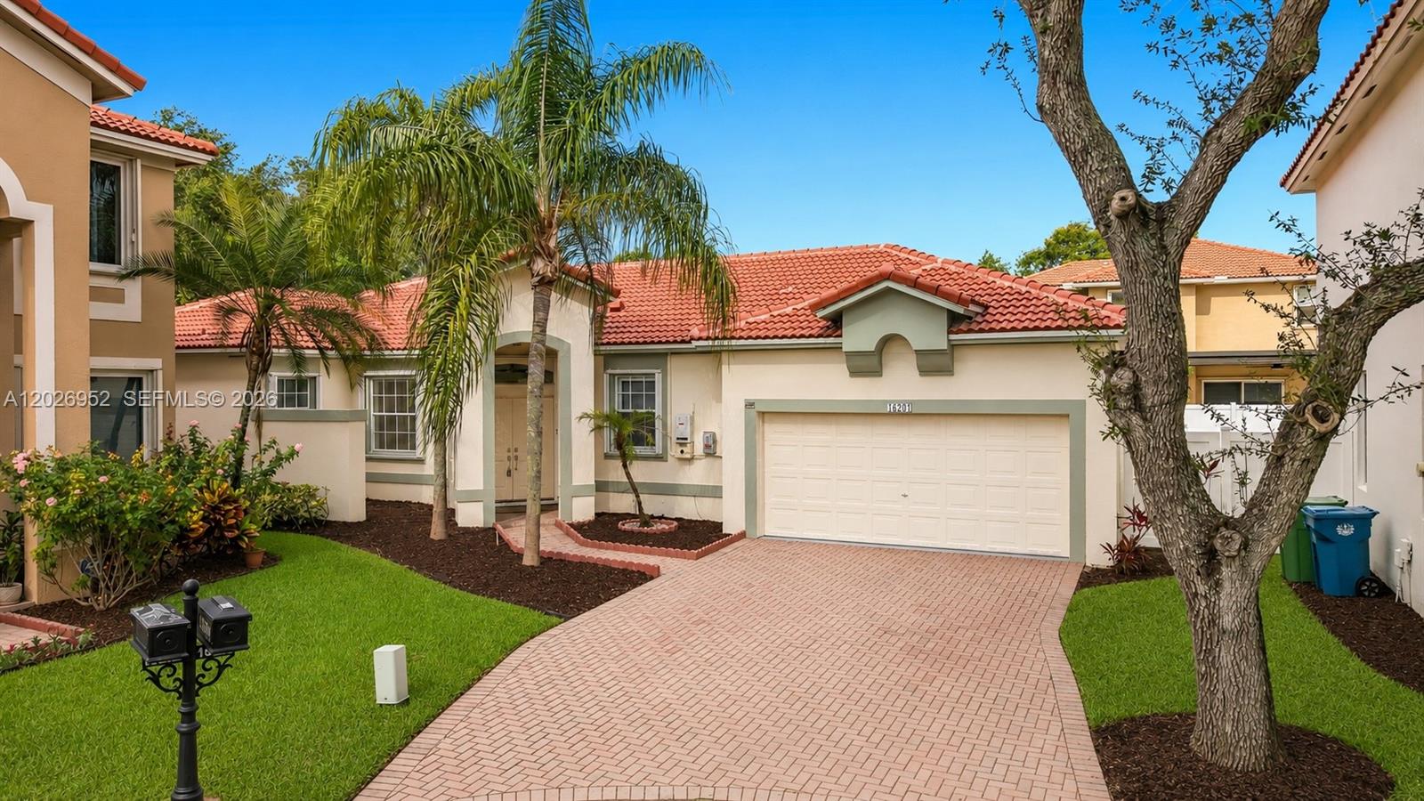 A single-story house with a tiled roof, a two-car garage, and a paved driveway — 16204 Opal Creek Dr, Weston FL 33331, WESTON, FL