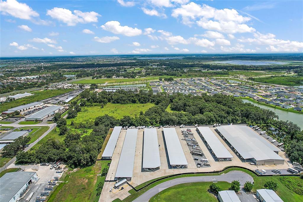 An aerial view shows a large storage facility with multiple covered bays and nearby residential neighborhoods — 4609 COUNTY ROAD 156, WILDWOOD, FL