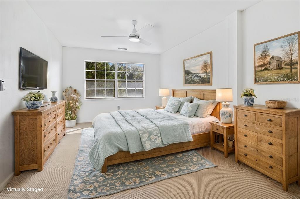 A bedroom features a wooden bed frame, two matching dressers, and a light blue rug — 3800 SAXON DRIVE UNIT C52, NEW SMYRNA BEACH, FL