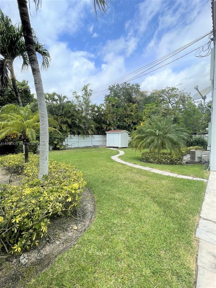 A grassy backyard features a winding stone path leading to a small white shed — 5116 SW 57th Ave # A, Miami FL 33155, MIAMI, FL