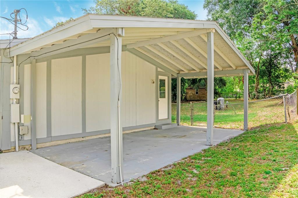 A single-story house with a white exterior, a concrete driveway, and an attached carport — 133 COLOMBA ROAD, DEBARY, FL