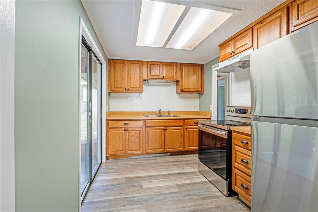 A bathroom features a white vanity, a toilet, and a walk-in shower with marble-look tiles — 133 COLOMBA ROAD, DEBARY, FL