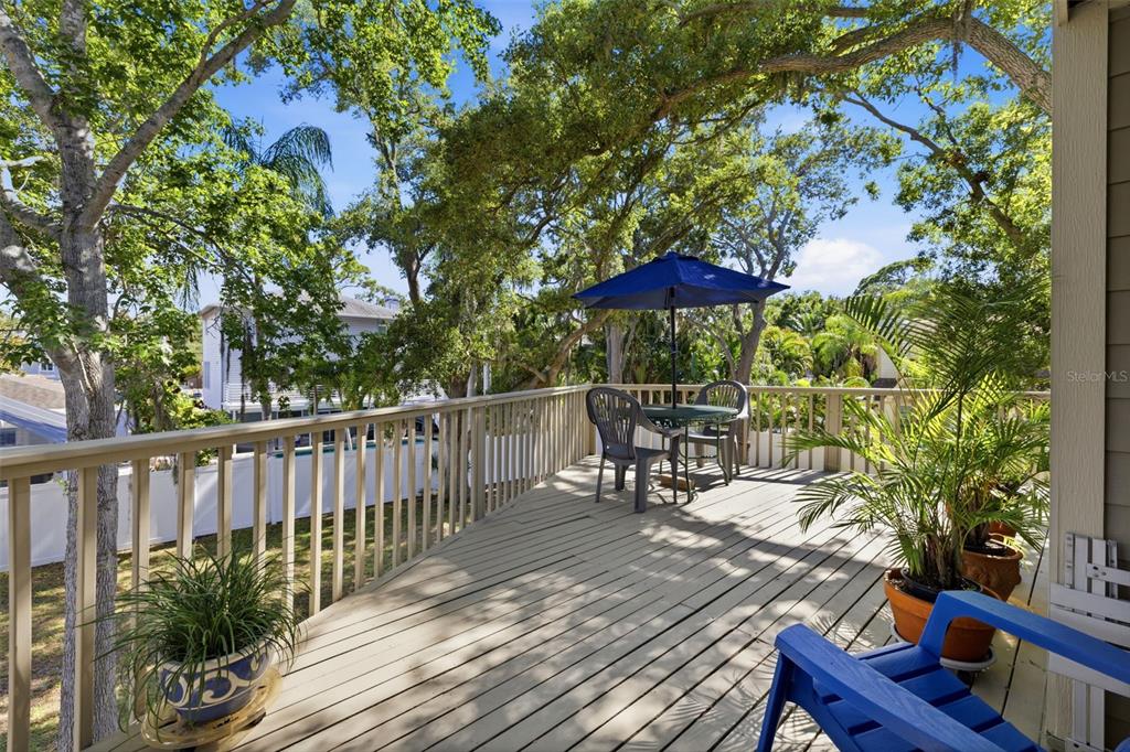 A wooden deck features a patio table with a blue umbrella and potted plants — 13150 72ND TERRACE, SEMINOLE, FL