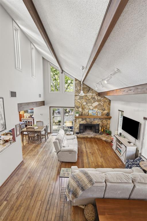 A high-ceilinged living room features a stone fireplace, wood flooring, and an adjacent dining area — 13150 72ND TERRACE, SEMINOLE, FL
