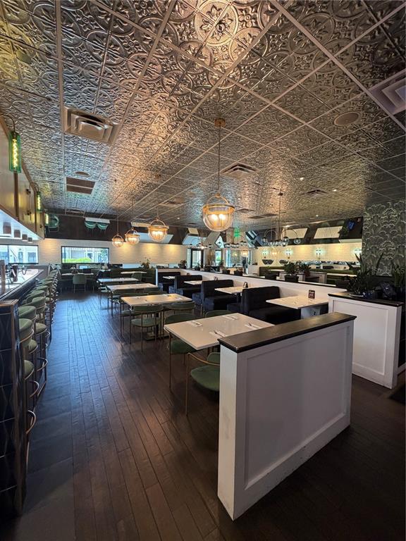 A restaurant interior features a patterned tin ceiling, dark wood floors, and booth seating — 13134 DALE MABRY HIGHWAY, TAMPA, FL