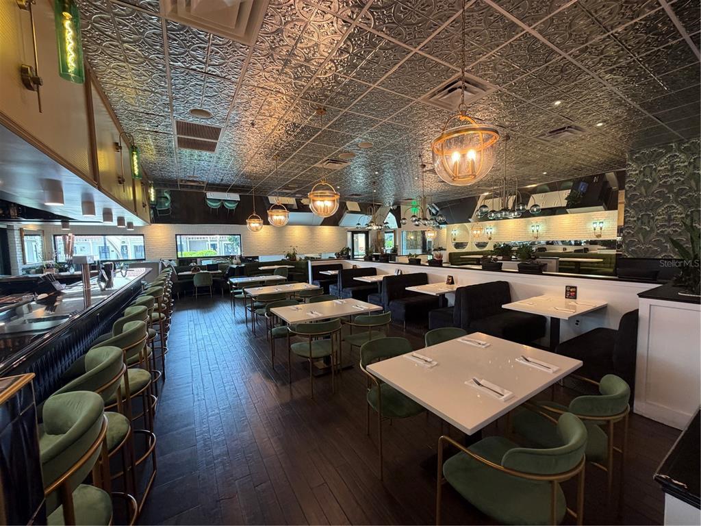 A restaurant interior features green velvet chairs, white tables, and a decorative metallic ceiling — 13134 DALE MABRY HIGHWAY, TAMPA, FL
