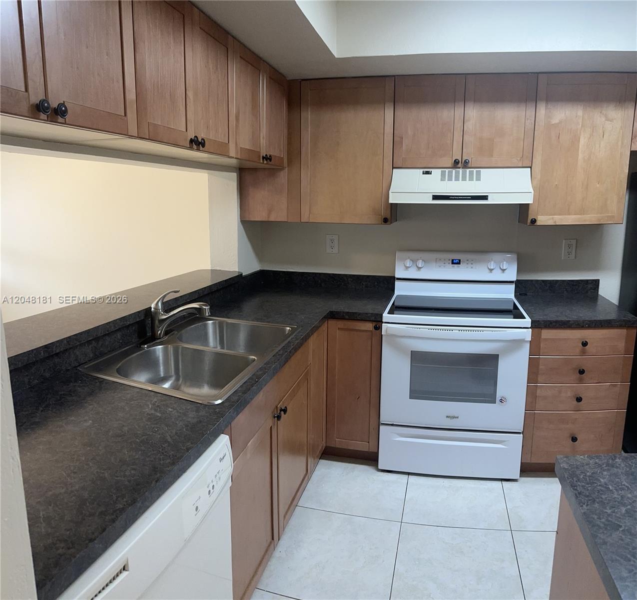 A kitchen features wood cabinets, dark countertops, a white stove, and a double sink — 7885 NW 7th Ct # 406, Plantation FL 33324, PLANTATION, FL