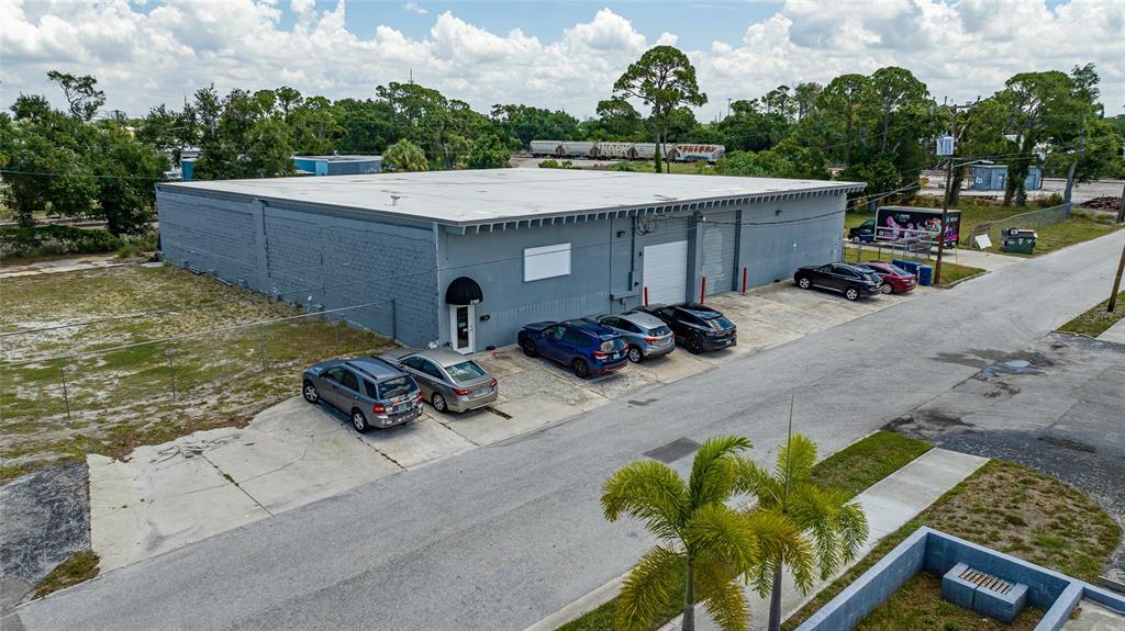 An aerial view shows a gray industrial warehouse building with a flat roof and parking lot — 2169 10TH STREET, SARASOTA, FL
