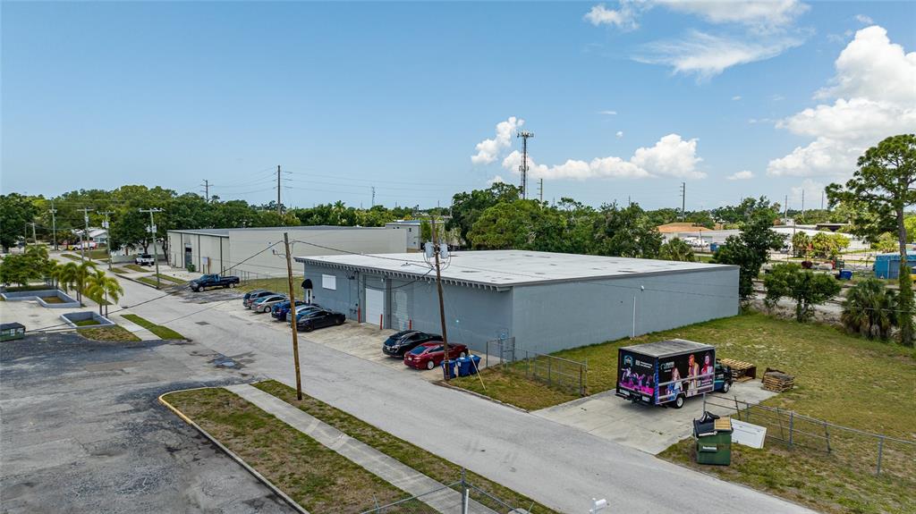 An aerial view shows a gray commercial warehouse building with a parking lot and trailer — 2169 10TH STREET, SARASOTA, FL