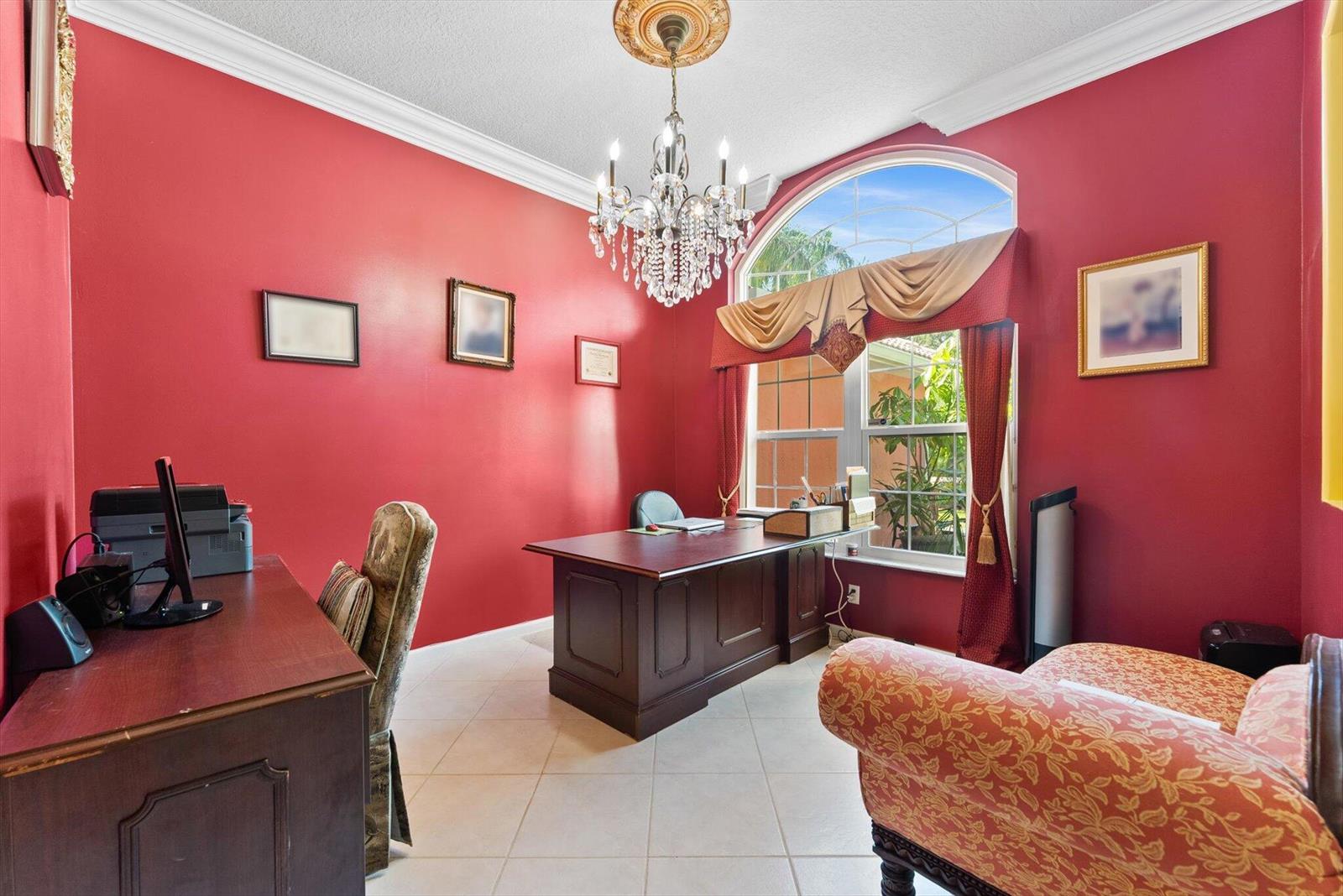 A home office features red walls, a crystal chandelier, a dark wood desk, and tile floors — 14844 Tangerine Boulevard, FL 33470, FL