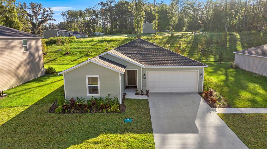 An aerial view of a light green single-story house with a two-car garage and lawn — 16983 NW 144TH STREET, ALACHUA, FL