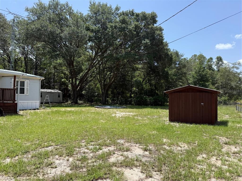 A backyard features a mobile home, a small shed, and a circular above-ground pool — 726 GUY AVENUE, INTERLACHEN, FL
