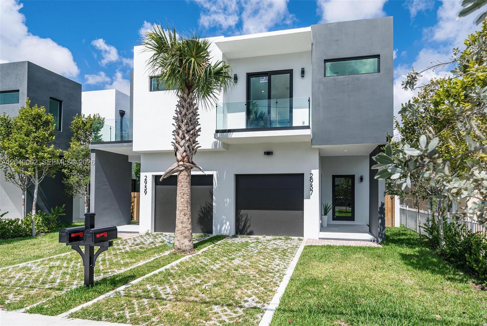 A modern two-story duplex features white and gray exterior walls, two garages, and a palm tree — 2939 SW 21st st, Miami FL 33145, MIAMI, FL