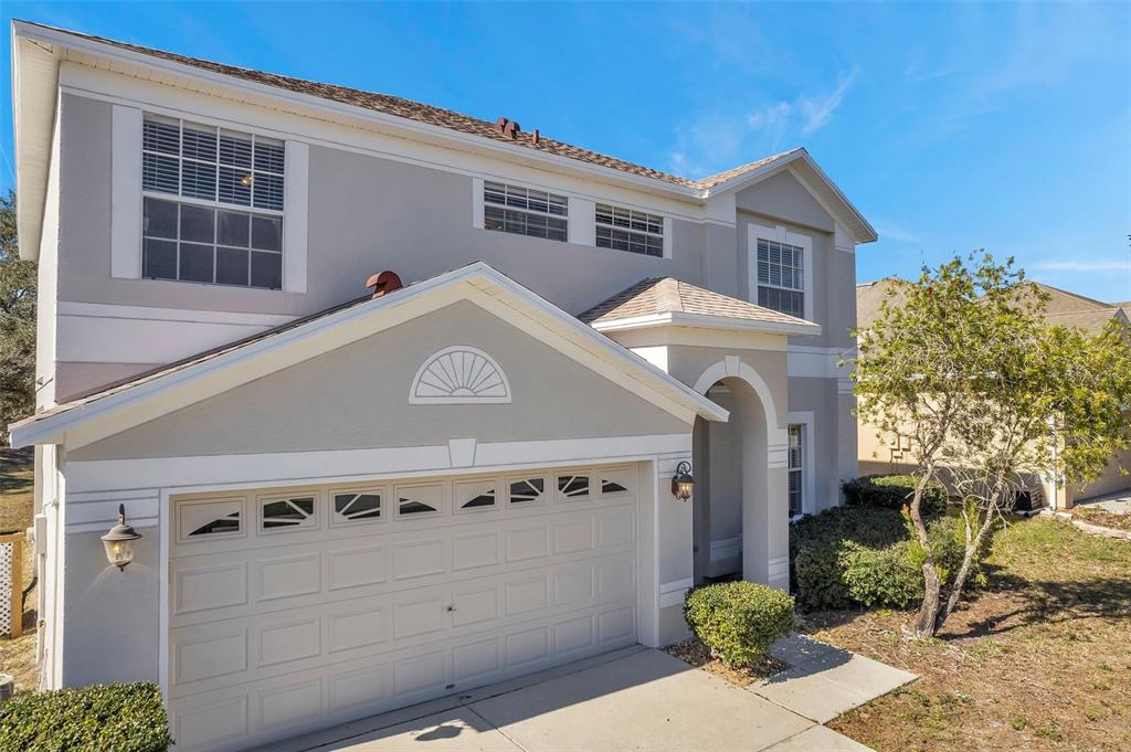 The exterior of a two-story house features a two-car garage and a covered entryway — 4069 BRAEMERE DRIVE, SPRING HILL, FL