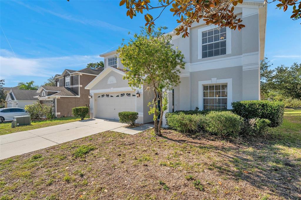 A two-story suburban house with a light-colored facade, a garage, and a front lawn — 4069 BRAEMERE DRIVE, SPRING HILL, FL