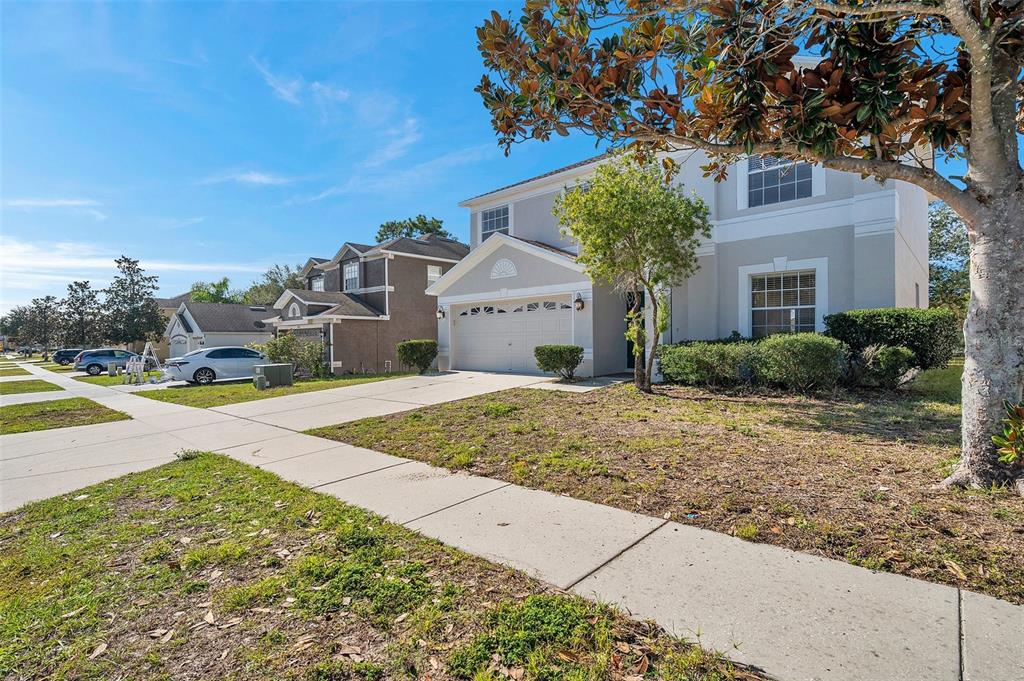 A two-story suburban house with a light-colored exterior, a garage, and a front lawn — 4069 BRAEMERE DRIVE, SPRING HILL, FL