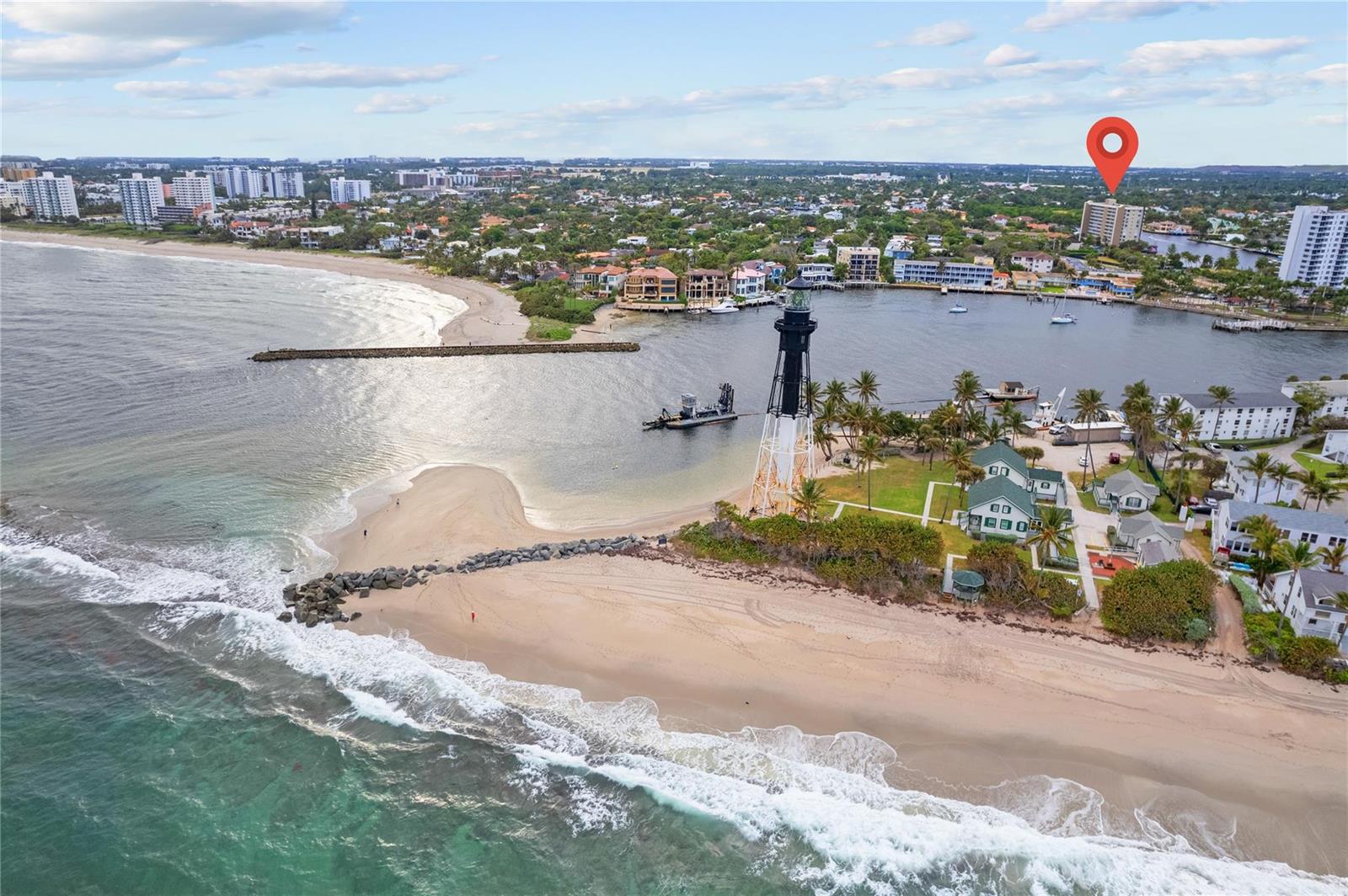 An aerial view shows the Hillsboro Inlet Lighthouse on a sandy beach near a waterway — 2611 N Riverside Drive # 307, Pompano Beach FL 33062, POMPANO BEACH, FL