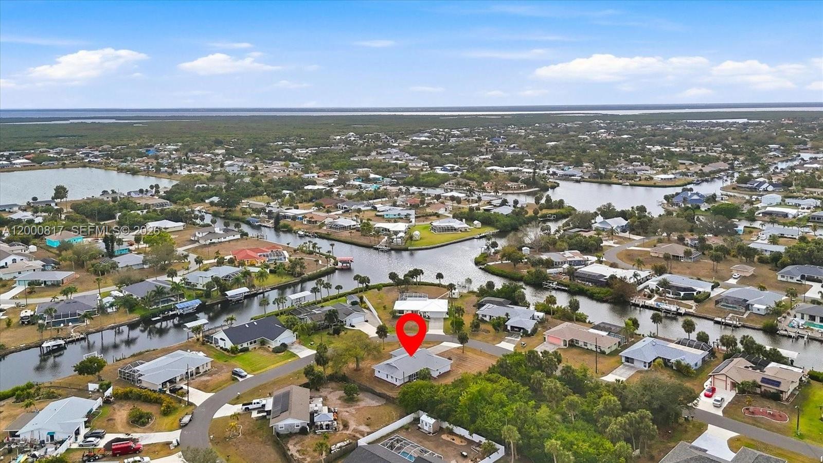 An aerial view shows a single-story house with a red location pin in a neighborhood — PORT CHARLOTTE, FL