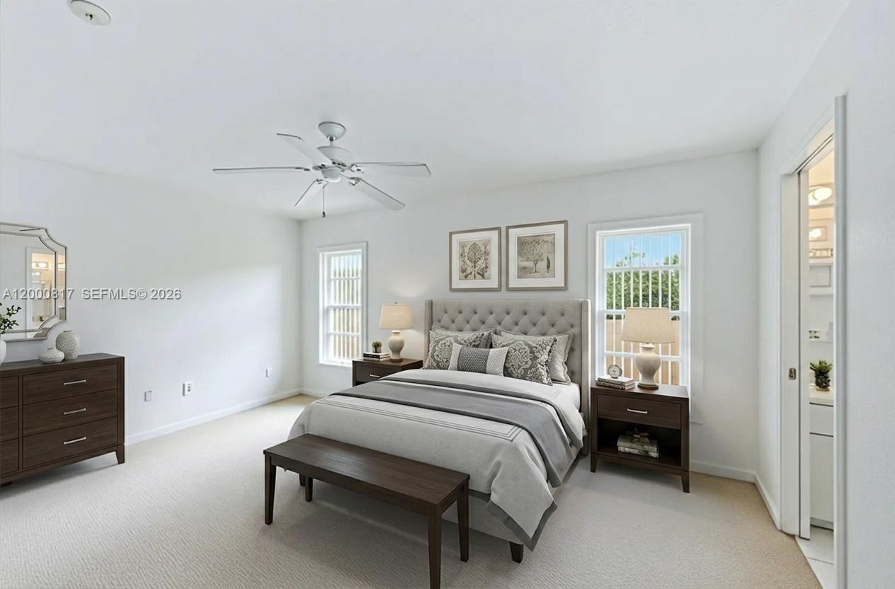 A bedroom features a tufted headboard, dark wood furniture, two windows, and a ceiling fan — PORT CHARLOTTE, FL