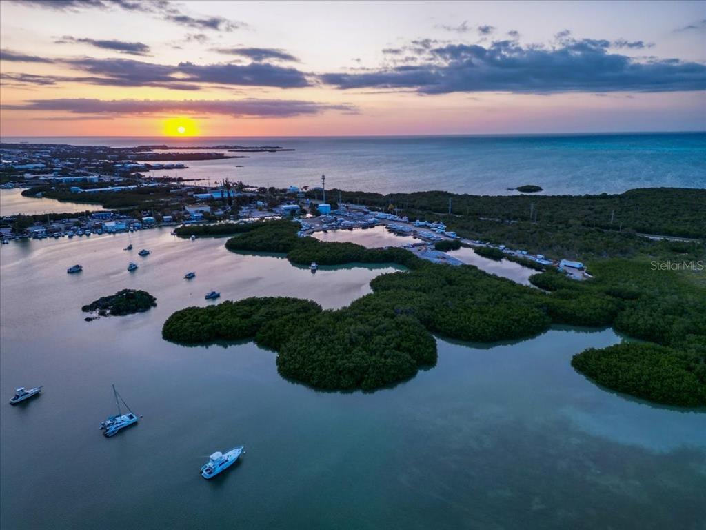 An aerial view shows a sunset over a coastal marina with boats and mangrove islands — 13900 OVERSEAS HWY, MARATHON, FL