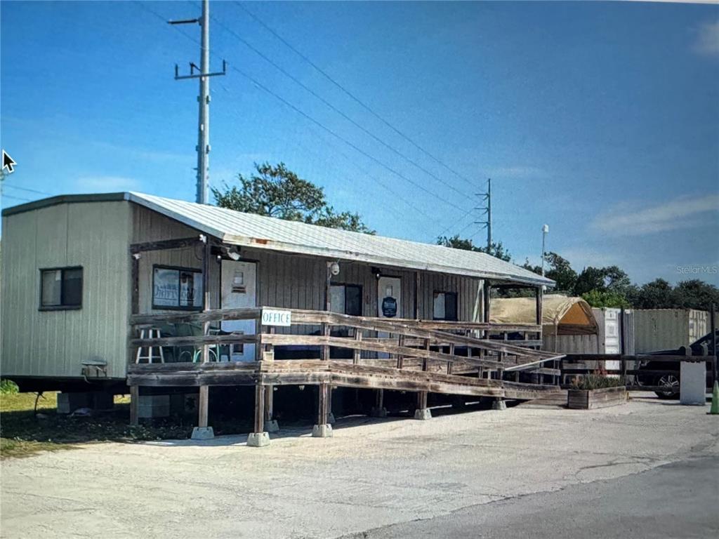 A single-story mobile home office building features a wooden porch with a wheelchair access ramp — 13900 OVERSEAS HWY, MARATHON, FL