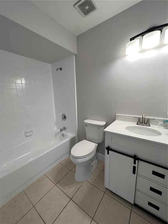 A bathroom features a white vanity, a toilet, and a tiled shower-tub combination — 1313 SUMMER BREEZE ROAD, ORLANDO, FL