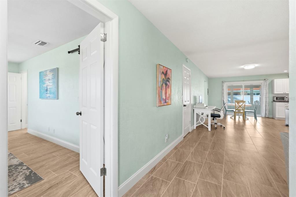 A view from a doorway shows a light-walled hallway leading into an open-concept living area — 341 PLAZA BOULEVARD, DAYTONA BEACH, FL