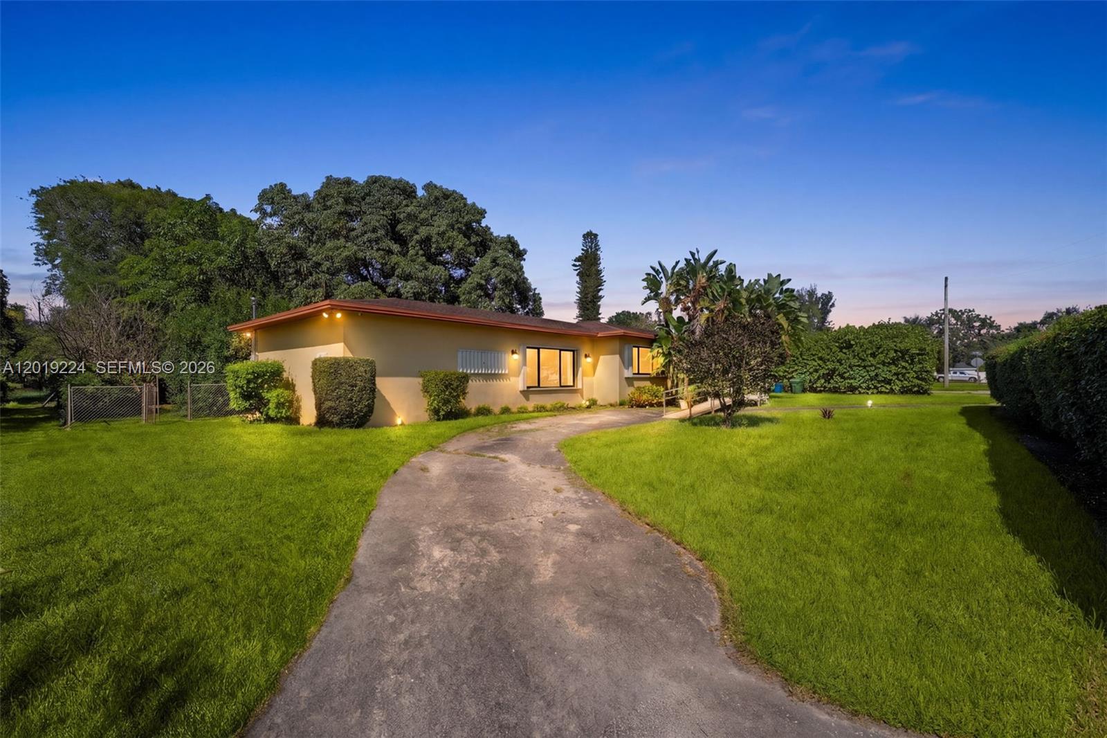 A single-story house with a yellow exterior and a curved driveway sits on a lawn — 511 Dunad Ave, Opa-Locka FL 33054, OPA-LOCKA, FL