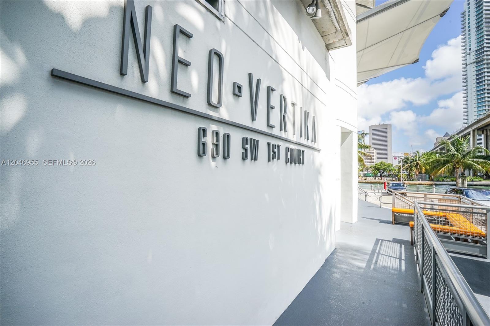 The exterior wall of a building displays the name Neo-Vertika with a metal railing nearby — 690 SW 1st Ct # 2707, Miami FL 33130, MIAMI, FL