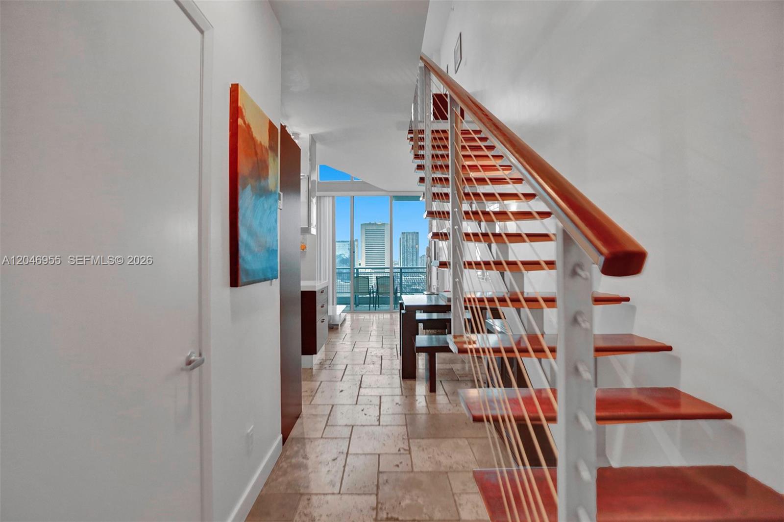 A hallway with tile flooring leads to a staircase and a view of city buildings — 690 SW 1st Ct # 2707, Miami FL 33130, MIAMI, FL