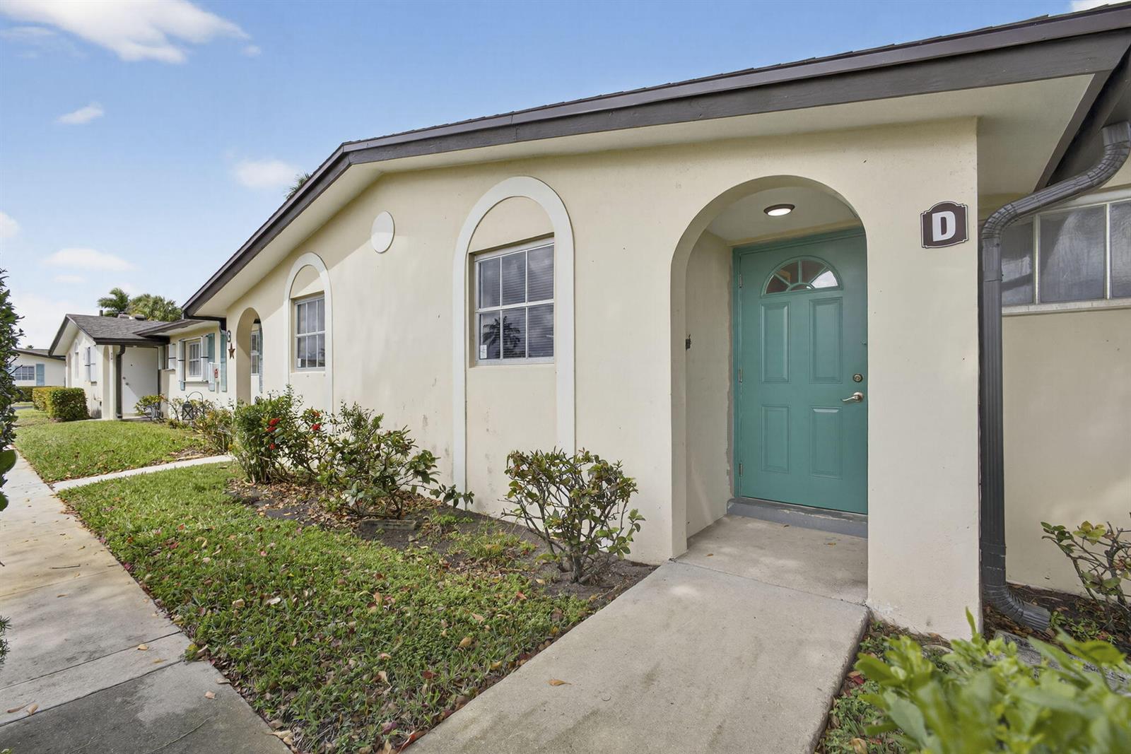 A single-story building with a teal front door marked with the letter D — 2960 Ashley Drive E # D, West Palm Beach FL 33415, WEST PALM BEACH, FL